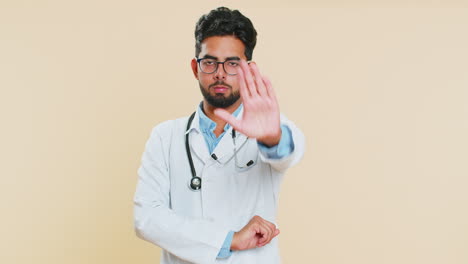 Doctor-man-say-no-hold-palm-folded-crossed-hands-in-stop-gesture-warning-of-finish-prohibited-access