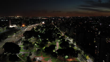 Vista-Aérea-Nocturna:-Horizonte-De-La-Ciudad-Y-Parque-Desde-Una-Perspectiva-Aérea