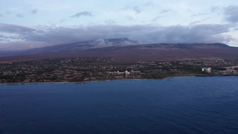Aerial-wide-push-in-shot-of-the-luxury-beach-resorts-in-Wailea-at-the-base-of-Haleakala-during-sunset-sunset-on-the-island-of-Maui-in-Hawai'i