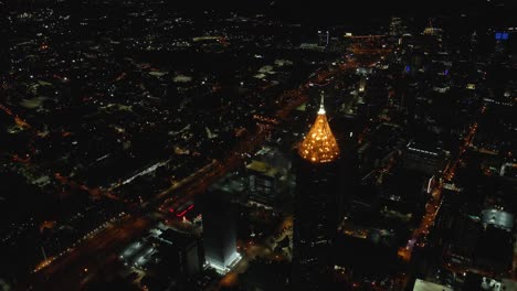 Eine-Atemberaubende-Nächtliche-Luftaufnahme-über-Die-Beleuchtete-Skyline-Der-Innenstadt