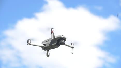 Quadrocopter-Drohne-Schwebt-Und-Fliegt,-Blauer-Himmel-Mit-Wolken-Im-Hintergrund