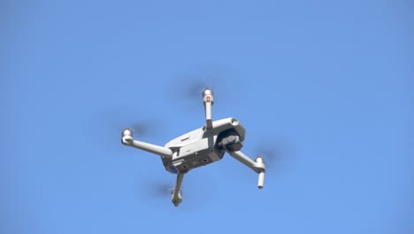 Drone-Equipado-Con-Cámara-Volando-Bajo-Un-Cielo-Azul-En-El-Fondo