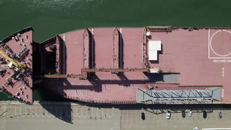 Kühle-Symmetrische-Überkopfaufnahme-Eines-Containerschiffs-Am-Dock,-4K-Drohnenaufnahme