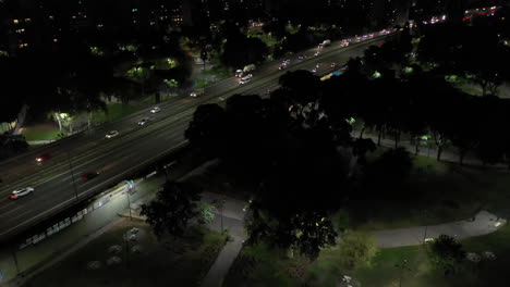 Moving-aerial-shot-of-night-in-the-park-and-avenue-with-traffic