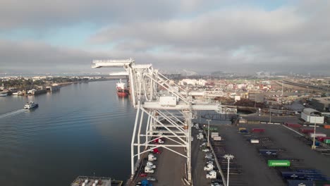Panoramic-aerial-of-cranes,-containers-and-ships-at-Port-of-Oakland,-4K-drone-shot