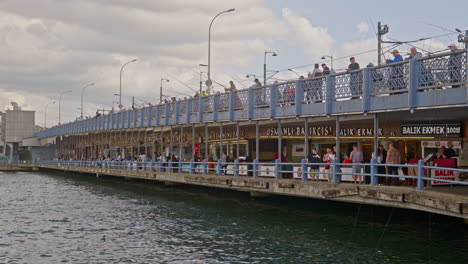 Angeln-über-Fischrestaurants,-Der-Berühmten-Galata-Brücke,-Eminonu,-Istanbul