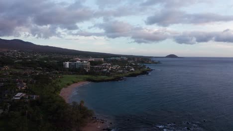 Low-panning-aerial-shot-of-luxury-beach-resorts-at-Wailea-during-sunset-in-South-Maui,-Hawai'i