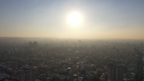 Langsame-Luftaufnahme-Eines-Tages-Mit-Nebel-Aufgrund-Der-Verschmutzung-Der-Skyline-Von-Buenos-Aires-Mit-Großer-Sonne-Der-Stadt-Buenos-Aires,-Argentinien,-Bei-Sonnenuntergang-Oder-Sonnenaufgang