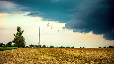 Zeitrafferaufnahme-Eines-Aufziehenden-Sturms,-Während-Sich-Die-Wolken-über-Der-Landschaft-Oder-Einem-Feld-Sammeln-Und-Auf-Einem-Feld-Schwarz-Werden,-Mit-Blick-Auf-Einen-Strommast-Im-Hintergrund