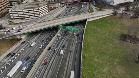 Aerial-birds-eye-shot-showing-busy-traffic-on-highway-with-bridge-during-sunny-day-in-Atlanta-City,-Georgia