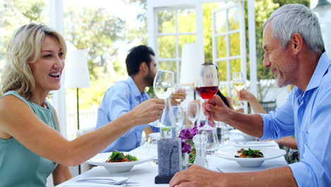 Two-friends-toasting-glasses-of-wine-in-restaurant