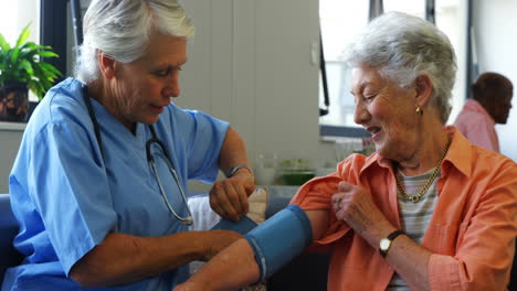 Female-doctor-checking-blood-pressure-of-senior-woman-4k