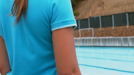 Girl-standing-near-the-swimming-pool-