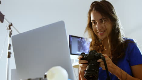 Weibliches-Model,-Das-Laptop-Und-Digitalkamera-4k-Betrachtet