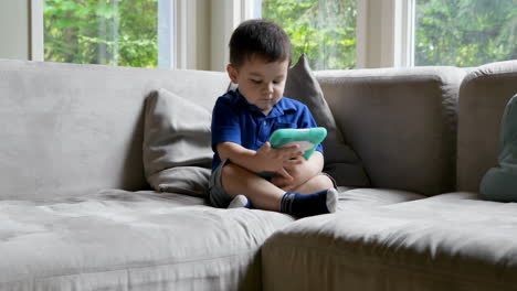 Baby-boy-using-digital-table-on-sofa-4k