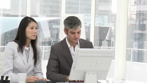 Attractive-business-woman-and-her-manager-working-at-a-computer