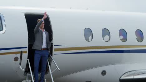 Businessman-waving-at-the-entrance-of-private-jet-4k