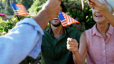 Familia-Sosteniendo-Banderas-Americanas-En-El-Parque-4k