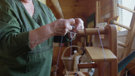 Senior-woman-placing-woollen-thread-on-weaving-machine-4k