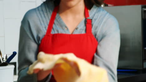 Female-baker-holding-dough-in-bakery-shop-4k