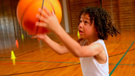 Athletic-African-American-schoolgirl-playing-with-basketball-in-basketball-court-at-school-4k