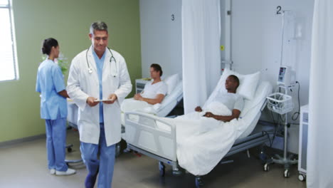 Front-view-of-Caucasian-male-doctor-talking-with-patient-in-ward-at-hospital