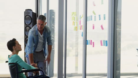 Caucasian-Business-people-discussing-over-sticky-notes-on-glass-wall-in-the-office-4k
