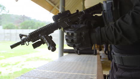 Mid-section-of-young-military-soldier-loading-rifle-magazine-during-military-training-4k