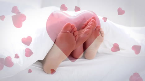 Couple-lying-in-bed-playing-with-feet