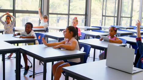 Schoolkids-raising-hands-in-the-classroom-at-school-4k