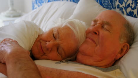 Close-up-of-Caucasian-senior-couple-sleeping-on-bed-in-bedroom-at-comfortable-home-4k