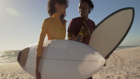 Couple-walking-together-with-surfboard-on-the-beach-4k