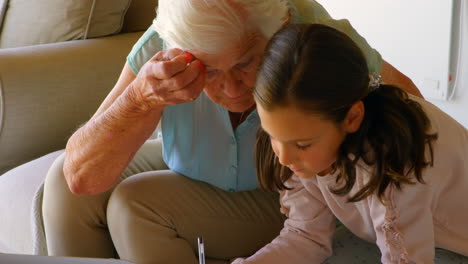Front-view-of-Old-Caucasian-grandmother-helping-her-granddaughter-with-homework-at-home-4k