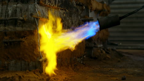 Close-up-of-metal-mold-heating-with-blow-torch-in-foundry-workshop-4k