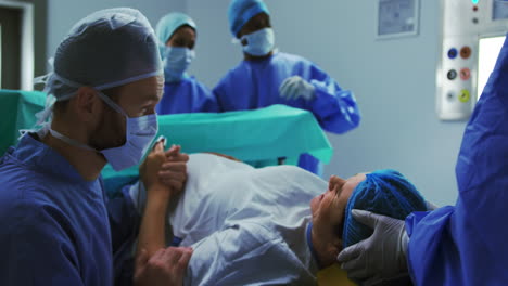 Side-view-of-Caucasian-man-comforting-woman-during-labor-pain-in-operation-theater-at-hospital-4k
