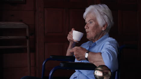 Woman-having-coffee-on-wheelchair-at-home-4k