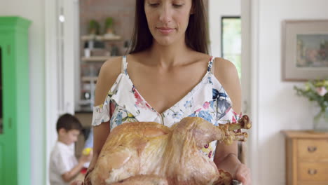 Woman-holding-tray-with-roasted-chicken-at-home-4k