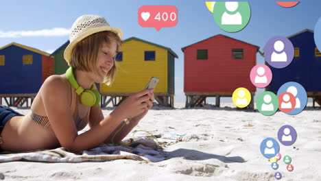 Multiple-profile-icons-floating-against-woman-using-smartphone-at-the-beach