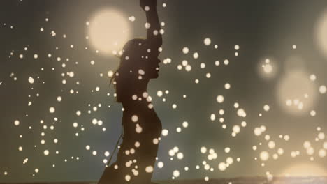 Golden-glowing-spots-moving-against-woman-performing-yoga-background-