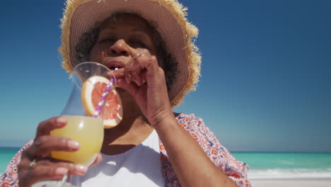 Senior-woman-drinking-a-cocktail-at-the-beach