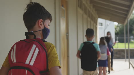 Group-of-kids-wearing-face-mask-standing-in-a-queue-in-school