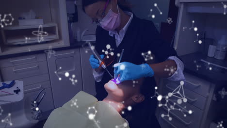 Glowing-molecular-structures-moving-against-dentist-treating-female-patients
