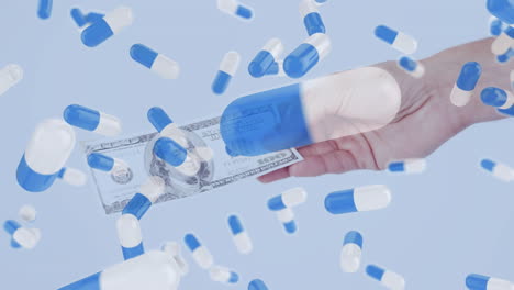 Animation-of-medical-pills-falling-over-a-hand-holding-an-American-dollar-bill.
