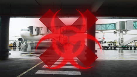Hazard-and-red-cross-sign-against-airport-runaway-in-background