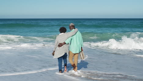 Senior-couple-walking-in-the-water-at-the-beach