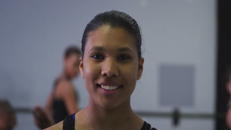 Portrait-of-a-mixed-race-modern-female-dancer-looking-at-the-camera