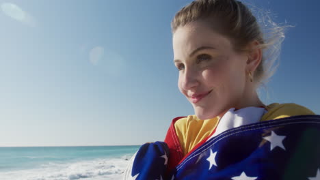 Woman-holding-American-flag-on-the-beach