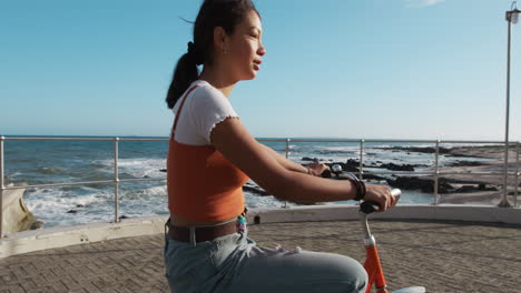 Seitenansicht-Eines-Gemischtrassigen-Mädchens,-Das-Am-Meer-Fahrrad-Fährt