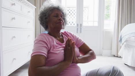 Ältere-Afroamerikanische-Frau,-Die-Zu-Hause-Im-Schlafzimmer-Yoga-Praktiziert