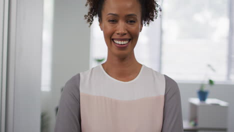 Portrait-of-mixed-race-businesswoman-smiling-to-camera-in-office